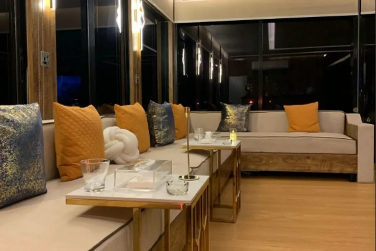 Indoor lounge of the King House Boat at night with cream sofas, orange cushions and gold side tables